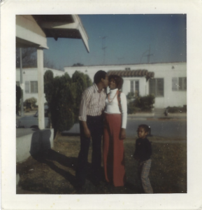 a scanned photo of Angela and her parents wearing 70 style clothing - bell bottoms.