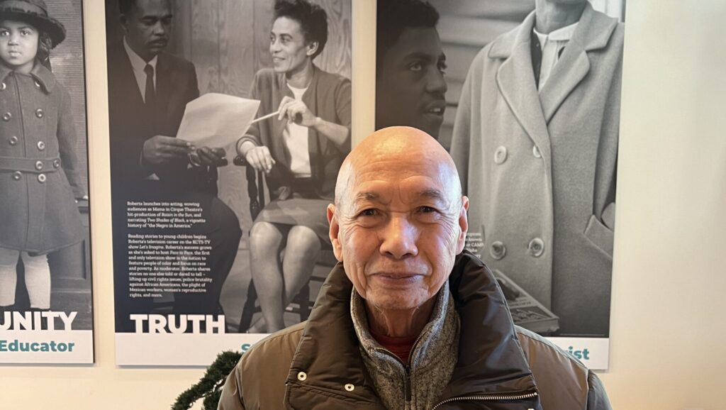 A mainstay of Byrd Barr Place for 26 years, Mr. Joseph Phan stands in front of an exhibit about the organization's namesake, Ms. Roberta Byrd Barr.