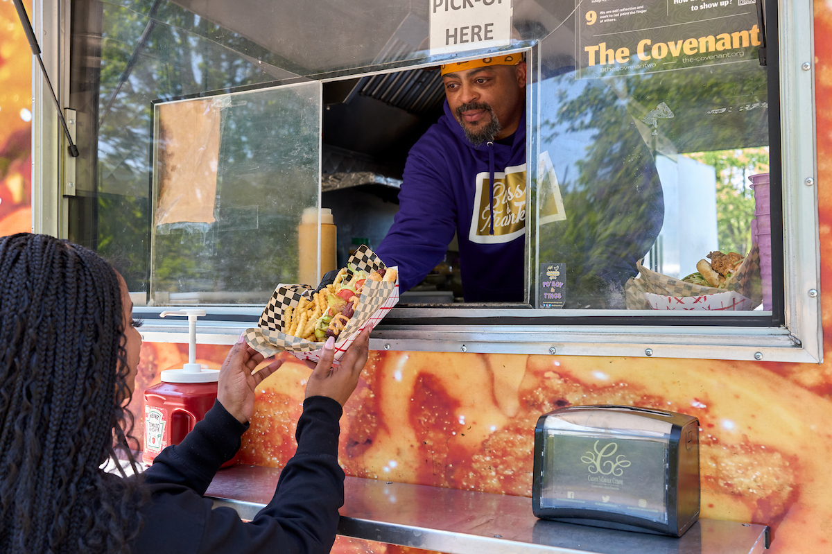CRP_Steve_Photo2 Man in food truck handing a basket of food to a customer