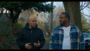 Two men walking outside while talking to each other